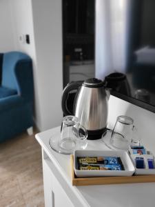 a tea kettle and glasses on a kitchen counter at Sky apartmani & spa in Leskovac