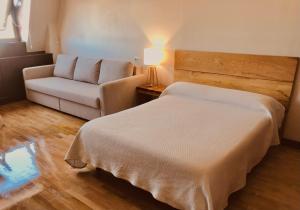 a small bedroom with a bed and a couch at Edificio El Moderno, Vigo 1.902 in Vigo