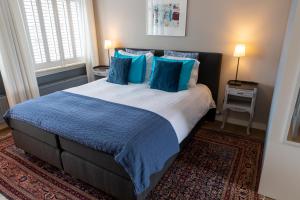 ein Schlafzimmer mit einem großen Bett mit blauen Kissen in der Unterkunft Guesthouse Thoez in Maastricht