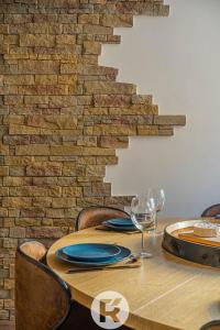 una mesa de madera con sillas y una pared de ladrillo en R'Apparts Le Petit Chalet du Téléphérique, en Grenoble