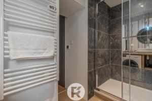 ein Bad mit einer Dusche und einer Glastür in der Unterkunft R'Apparts Le Petit Chalet du Téléphérique in Grenoble