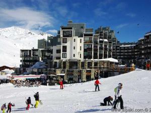 a group of people skiing in the snow in front of a building at Appartement Tignes, 2 pièces, 7 personnes - FR-1-449-65 in Tignes