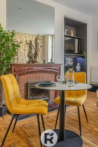 a living room with a table and two yellow chairs at R'Apparts Studio Chic des Quais in Grenoble