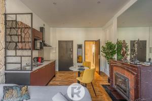 a kitchen and living room with a couch and a fireplace at R'Apparts Studio Chic des Quais in Grenoble