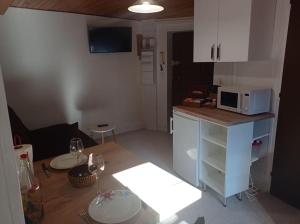 eine kleine Küche mit einer Theke und einer Mikrowelle in der Unterkunft Appartement cosy avec son charme ancien. in Saint-Claude