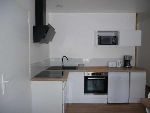 una cucina bianca con lavandino e forno a microonde di Appartement T2, au calme. a La Roche-sur-Yon