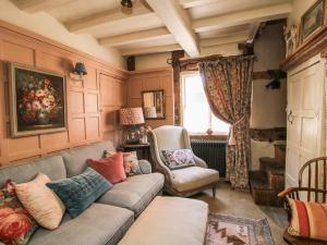 a living room with a couch and two chairs at Cobblers Cottage in Whitchurch