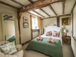 a bedroom with a bed with two towels on it at Cobblers Cottage in Whitchurch