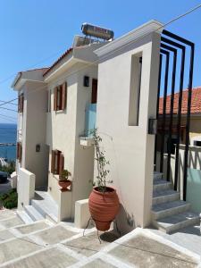 a house with a potted plant in front of it at Archo Suites Pythagoreio in Pythagoreio