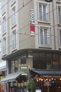 a street sign on a pole in front of a building at Neda Hotel Istanbul in Istanbul