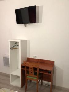 Elle comprend un bureau avec une chaise et une télévision murale. dans l'établissement Hôtel Central Bastille, à Paris