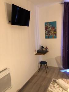 Televízia a/alebo spoločenská miestnosť v ubytovaní Hôtel Central Bastille
