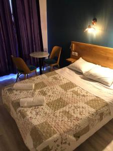 - une chambre avec un lit, 2 chaises et une table dans l'établissement Hôtel Central Bastille, à Paris