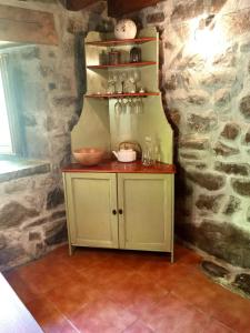 a small cabinet in a room with a stone wall at La Cabaña del Río in San Roque de Ríomiera