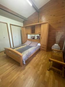 a bedroom with a bed and a wooden floor at Village de gites Mas de la Bastide in Joyeuse