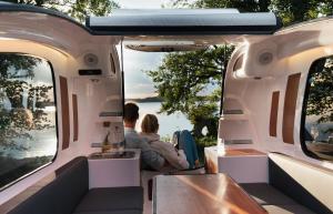 Ein Mann und eine Frau sitzen hinten im Van. in der Unterkunft Sealander - Tiny Wohnwagen und Boot - Ferienwohnung Creutzig am Campingplatz Schachenhorn in Bodman-Ludwigshafen