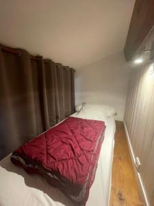 a small bedroom with a bed with a red blanket at Village de gites Mas de la Bastide in Joyeuse