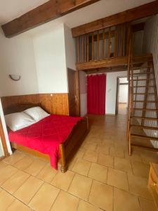 a bedroom with a bed with a red blanket at Village de gites Mas de la Bastide in Joyeuse