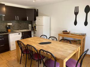 a kitchen with a wooden table and some chairs at Village de gites Mas de la Bastide in Joyeuse