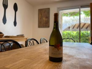 - une bouteille de vin assise sur une table dans l'établissement Village de gites Mas de la Bastide, à Joyeuse