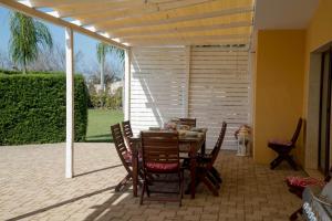 ein Esszimmer mit einem Tisch und Stühlen auf einer Terrasse in der Unterkunft Villa Taranta in Racale