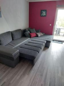 a couch in a living room with a red wall at Schöne Wohnung direkt am Bach in Neunkirchen am Sand