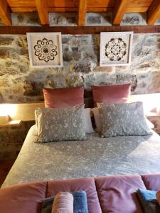 - une chambre avec un canapé et un mur en pierre dans l'établissement La Cabaña del Río, à San Roque de Ríomiera