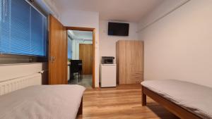 1 dormitorio con 1 cama y nevera pequeña en HÉDER APARTMANOK, en Balatonfenyves