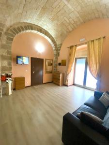 un ampio soggiorno con divano e soffitto in pietra di The Nest of Envy a Bari