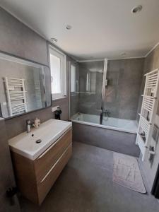 een badkamer met een bad, een wastafel en een bad bij Superbe Rez-de-Jardin refait à neuf. in Breil-sur-Roya