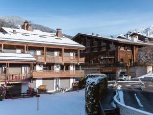 a large wooden building with snow on it at Appartement Confortable au Coeur du Village, Proche des Pistes avec Terrasse et Garage - FR-1-304-191 in La Clusaz