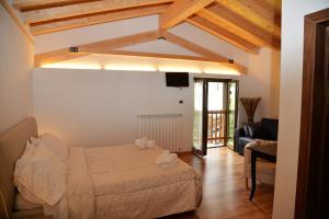 a bedroom with a bed and a living room with a couch at Hotel Marianna in Rocca Pietore