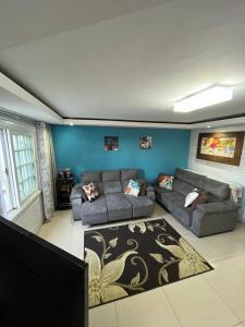 un soggiorno con 2 divani e un tappeto di Sobrado Bairro Alto a Curitiba