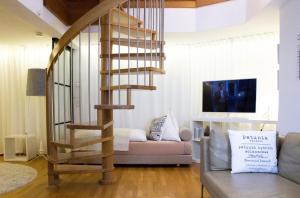 a spiral staircase in a living room with a couch at Como Design-Apartment close to Isar river area - centrally located in Munich