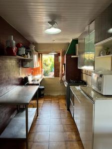 a kitchen with a table and a microwave at Sobrado Bairro Alto in Curitiba