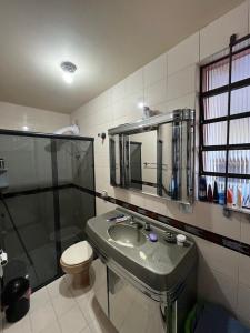a bathroom with a sink and a toilet and a shower at Sobrado Bairro Alto in Curitiba