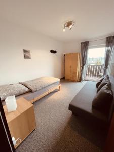 a bedroom with a bed and a couch and a window at Ferienwohnung Bienenkorb in Selb