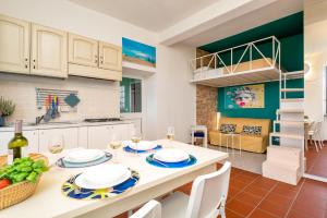 a kitchen and living room with a table and chairs at Sunset Lovers, Terre Marine in San Bernardino