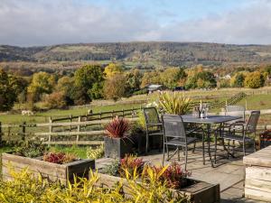 a patio with a table and chairs and a field at Grove Farm Barn in Matlock