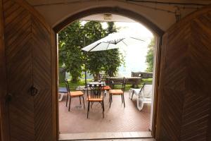 patio con tavolo, sedie e ombrellone di Holiday Home Liberg with Hot tub and Sauna a Brežice
