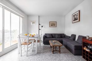 ein Wohnzimmer mit einem Sofa und einem Tisch in der Unterkunft Résidence Belle Vue YourHostHelper in Arcachon