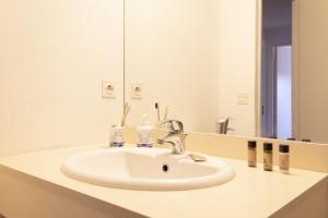 eine Badezimmertheke mit einem Waschbecken und einem Spiegel in der Unterkunft Résidence Belle Vue YourHostHelper in Arcachon