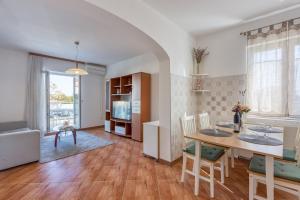 kuchnia i salon ze stołem i krzesłami w obiekcie Apartments Azra w Puli