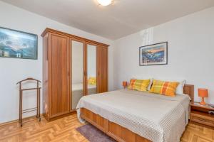 sypialnia z łóżkiem i drewnianą szafką w obiekcie Apartments Azra w Puli