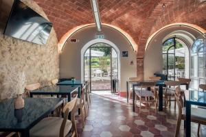 un restaurante con mesas, sillas y ventanas en La Locanda di Petriolo, en Monticiano