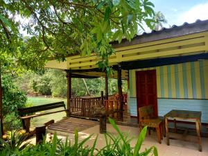 a porch of a house with a bench and a table at Ao Jark Homestay in Ban Bang Bao