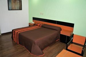 a bedroom with a large bed with a wooden headboard at Hotel Castro in Mexico City