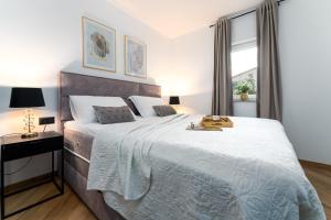Un dormitorio con una cama grande y una ventana en Luxury apartment Love Nest - near the center and the beach, en Krk