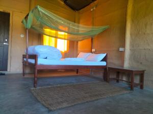 Bett in einem Zimmer mit Moskitonetz in der Unterkunft Namaste Bardiya Resort in Bhurkīā