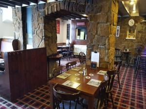 a dining room with a wooden table and chairs at Royal Oak in Hunmanby